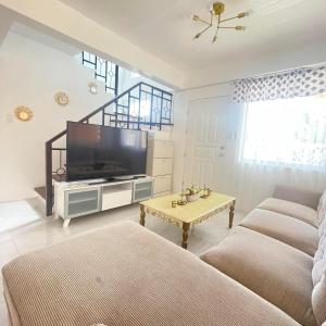 卡加盐德奥罗4BEDROOMS Elegant House For Family & Groups Staycation In Cagayan de Oro City的客厅配有电视、沙发和桌子