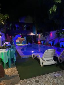 奥林达Ladeira de Olinda的夜间游泳池,配有椅子和桌子