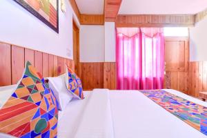 马拉里FabHotel Elavali Valley的卧室配有白色的床和粉红色窗帘