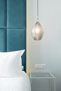 埃尔莫波利斯DIIO Suites的一间卧室配有一张床和吊灯