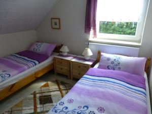 泰克伦堡Ferienwohnung的配有紫色床单的小客房内的两张床