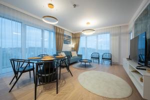 达尔沃沃Marina Royale Darłowo - Apartamenty Vista Mar nad morzem的客厅配有桌椅和沙发