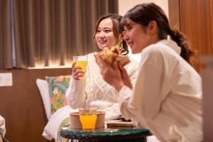 北谷町Aqua Resort in Chatan的坐在桌子上吃比萨饼的两位妇女