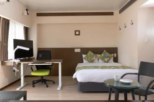北谷町Aqua Resort in Chatan的一间卧室配有一张床和一张带电脑的书桌