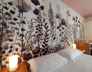 切萨雷奥港Hotel Grecale的卧室的墙上挂着花卉壁画
