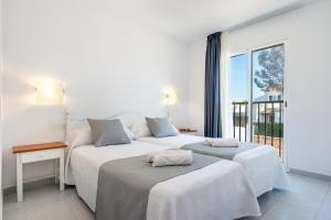 萨卡莱塔Vibra Caleta Playa Apartmentos-3SUP的带大窗户的客房内的两张床