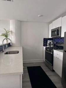 DarbyMEB Loft的白色的厨房设有水槽和炉灶。