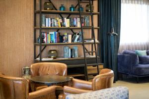 马略卡岛帕尔马加泰罗尼亚马略卡酒店的客厅配有桌椅和书架