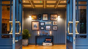 特拉利阿什酒店的走廊上设有蓝色门,墙上挂有图片