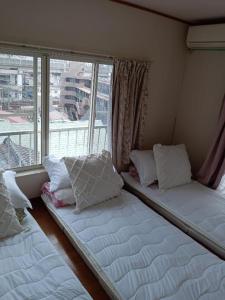 东京Tokyo downtown的带大窗户的客房内的两张床