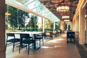 托马尔Estalagem Santa Iria Hotel & Spa的一间带桌椅和窗户的用餐室