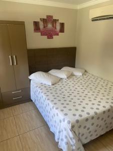 邦比尼亚斯Residencial Cecilia Cruz的一间卧室配有带白色床单和枕头的床。