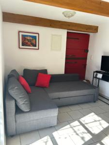 戈尔德La Forge - Gordes的客厅里配有带红色枕头的灰色沙发
