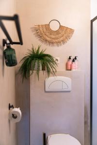 洛克伦KROOST的一间带卫生间的浴室和墙上的植物
