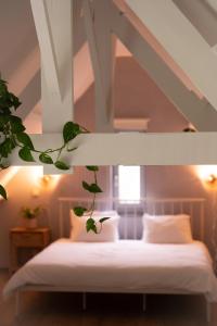 洛克伦KROOST的卧室配有白色床,上面种植了植物