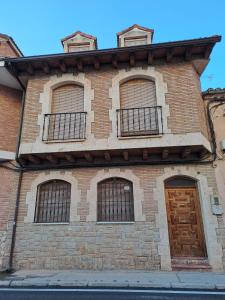 OsmaWAXSIMA Burgo de Osma的砖砌的建筑,有四扇窗户和门