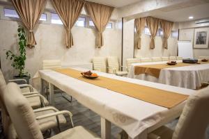锡纳亚马雷亚尼亚格拉酒店的一间会议室,配有白色的桌椅