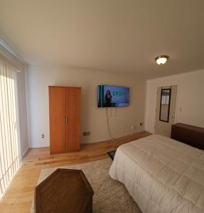纽瓦克Traveler's Lodge In Newark City的卧室配有一张床,墙上配有电视。