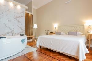博萨Palazzo Pischedda的卧室配有一张白色大床和浴缸