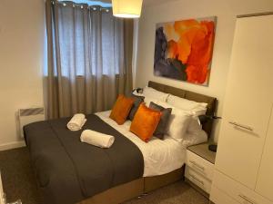 帕德西Convenient 2 Bedroom Ground floor Apartment with Parking in Leeds的一间卧室配有带橙色和白色枕头的床