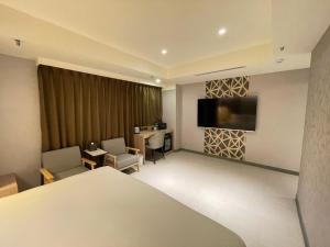 台北新仕飯店-New City Hotel的配有一张床和一台平面电视的酒店客房