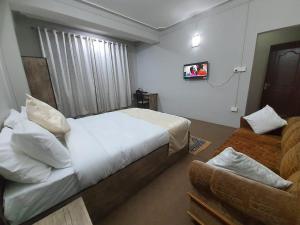 甘托克Payong House的卧室配有白色的床和沙发