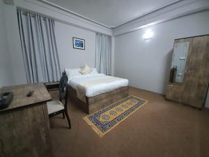 甘托克Payong House的一间卧室配有一张床、一张桌子和一张书桌