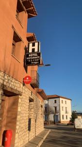 Torres de AlbarracínHotel el Cid的建筑一侧的酒店标志