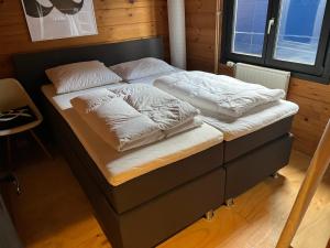 埃尔默洛FINS Holiday Home的一张带白色床单和枕头的床