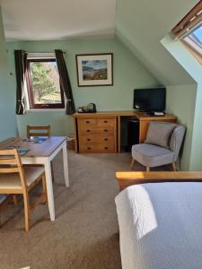 阿勒浦Croft 17的一间卧室配有书桌、桌子和椅子