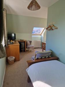 阿勒浦Croft 17的一间卧室配有一张床、一张书桌和一台电视。