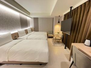 台北新仕飯店-New City Hotel的酒店客房设有两张床和一台平面电视。