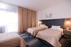 贝尔格莱德斯拉维娅酒店的酒店客房设有两张床和窗户。