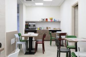 维罗港Al Bacino Rooms And Breakfast的用餐室配有桌子和绿色椅子
