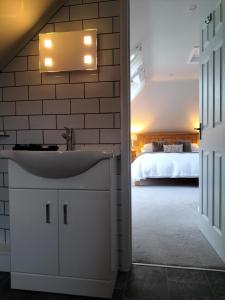 埃克塞特Valley House的一间带水槽的浴室和一张位于客房内的床
