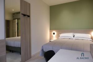 维罗港Al Bacino Rooms And Breakfast的一间卧室配有两张床、一张桌子和一面镜子