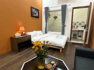 河内Hanoi Old Quarter Inn的配有床和鲜花桌的酒店客房