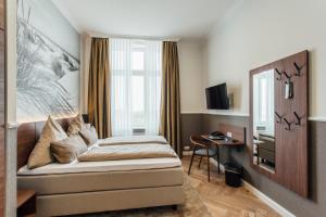 博尔库姆霍亨索伦海滩酒店的一间卧室配有一张床、一张书桌和一个窗户。