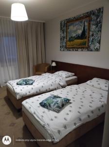 罗兹Campoverde的酒店客房设有两张床,墙上挂着一张照片。