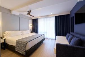 马略卡岛帕尔马加泰罗尼亚马略卡酒店的酒店客房,配有床和沙发