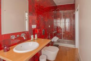 波尔图Fil's Place的红色瓷砖浴室设有水槽和卫生间