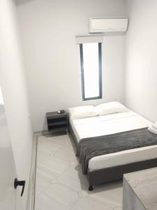 El PobladoHotel la Carpita的白色的卧室设有床和窗户