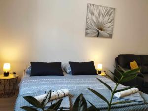 科米扎Anne的一间卧室配有一张带蓝色床单和植物的床