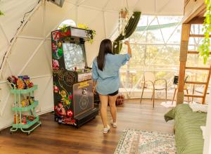Tiny Pines A-Frame Cabin, Domes and Luxury Glamping Site的一名妇女在房间里玩电子游戏