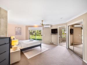 黄金海岸Modern 4BR Holiday Home W Pool BBQ Oxenford的一间卧室设有一张床和一个滑动玻璃门