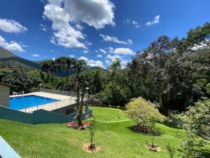 伊泰帕瓦Casa Feliz no Jardim Itaipava, 7 quartos, conforto的后院设有游泳池和草地庭院