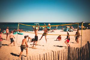 圣特罗佩金羊毛酒店的一群人在沙滩上打排球