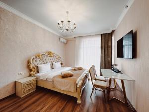 埃里温Armenia Hotel的一间卧室配有一张床、一张桌子和一个吊灯。