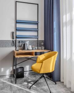 基辅IQ酒店的客房内的黄色椅子和书桌