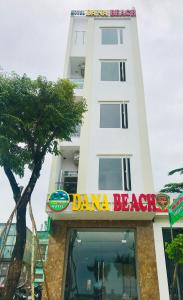 岘港DanaBeach Motel的前面有 ⁇ 树海滩标志的白色建筑